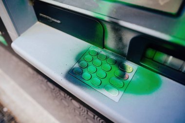 Bir Fransız ATM 'si, gösteri sırasında hasar görmüş ve yeşil boya grafitiyle kaplanmış. Tuş takımı, aygıtın müşteriler tarafından tekrar kullanılabilmesi için kaldırılmasını bekliyor.