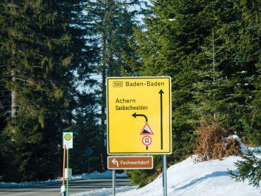 Baden-Badem Achern 'e giden yolu gösteren karla kaplı bir okun içinde bir uyarı işareti yalnız duruyor. Etrafındaki ağaçlar ve bitkiler ürkütücü bir sessizlik yaratıyor..