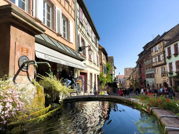 2022年9月22日フランス リキューヒール フランス アルザス州リキューヒールの古代都市では 青い空に対して鮮やかな花に囲まれた運河や噴水のある建物のヴィンテージビューは それを作る — ストック写真