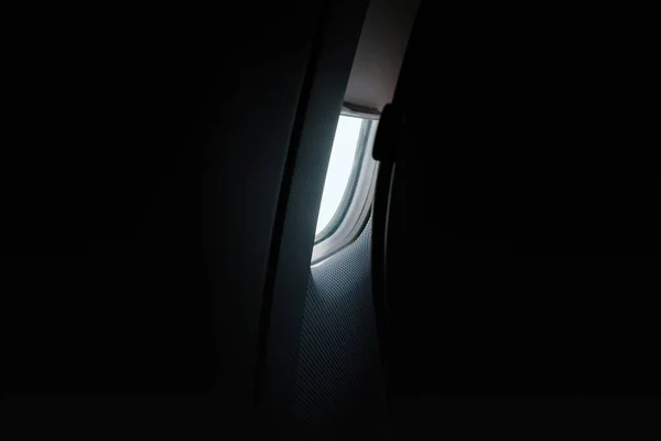 暗闇に照らされた黒い航空機の窓からは 屋内から神秘的な屋外の景色を眺めることができます — ストック写真