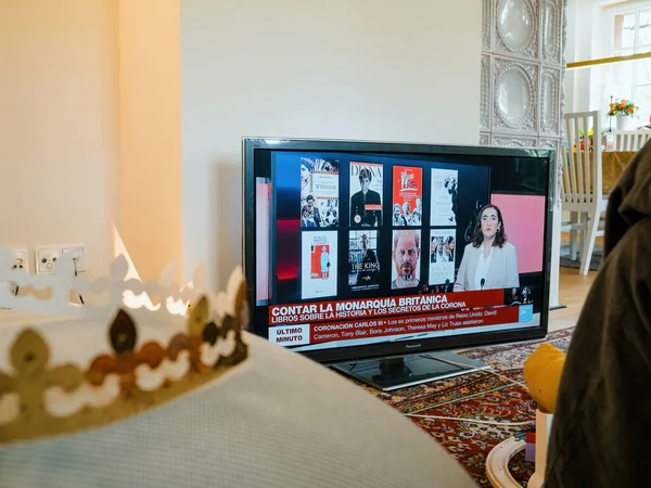 フランス 2023年5月6日 チャールズ3世とカミラがフランスのニュースチャンネルで英国の王と女王を戴冠すると 女性の腕時計 君主制のレビューに関する本は彼女の後ろに横たわっていた — ストック写真