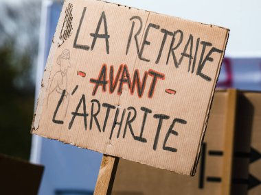 Strasborg, Fransa - 29 Mart 2023: Fransa 'da bir protestocu, artrit başlamadan önce emeklilik reformunu savunan bir pankart tuttu.