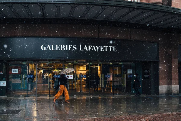 2021年1月14日 法国斯特拉斯堡 一个女人带着雨伞走在潮湿多雪的城市里 欣赏着标志性的时尚目的地 加利利 拉法耶特 — 图库照片