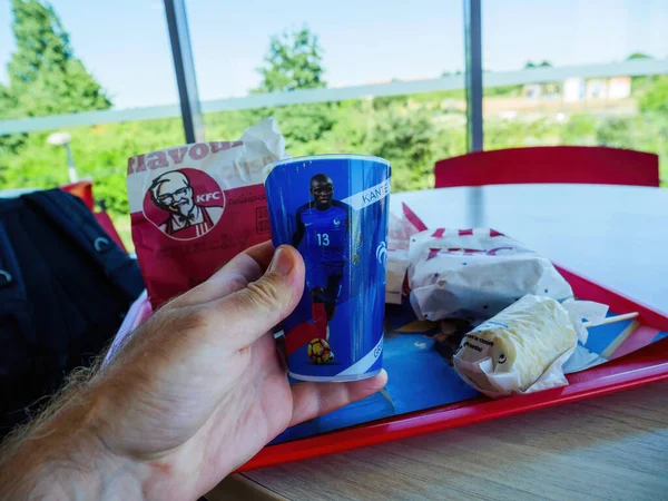 フランス 6月28 2018 サッカーのフランスチームとプラスチックカップを片手に箱を保持し 男は喜んでおいしいKfc食事を食べます — ストック写真
