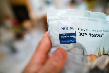 Paris, Fransa - 2 Mayıs 2023: Bir müşteri Philips Su Çözümleri su filtresi açmaya hazır hindistan cevizi ve kömürden mikro X-Clean parçacıkları ile, taze ve saf su tatma suyu sunuyor.
