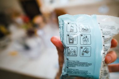 Paris, Fransa - 2 Mayıs 2023: Bir kişi hindistan cevizi ve kömürden mikro X-Clean parçacıkları ile Philips Su Çözümleri filtresi açmaya hazır - okuma talimatları