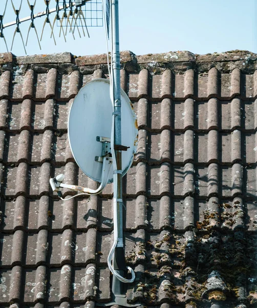 一个覆盖着苔藓的现代屋顶 装饰着卫星天线和数字电视天线 被温暖的白昼照亮 — 图库照片