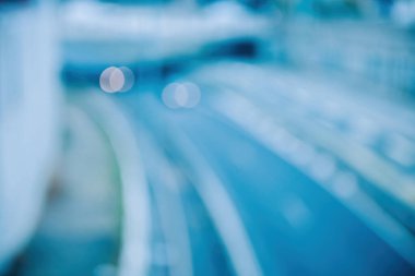 La Defense, Paris 'teki boş bir otoyolda hızlı giden bir arabanın hava görüntüsü. Bokeh ve bulanıklık canlı bir arkaplan oluşturur mavi renk döküm ve ışık parlaklığı.