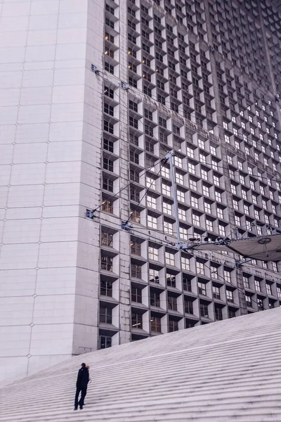 明るい日に大都市の建物の外壁階段を断固として登る人のシルエット — ストック写真