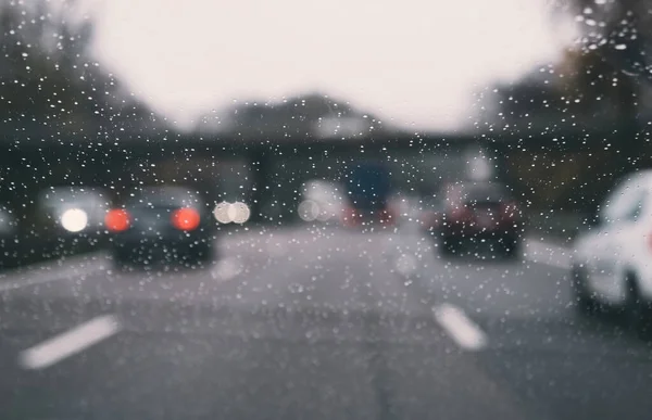 透明感のある車の窓からは雨 ぬれた街並みが見える 交通のぼやけた景色は 外の霜と氷の天気条件を反映しています — ストック写真