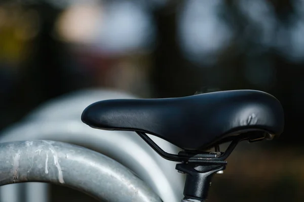 革のバイクシートとギアの詳細が鋭い焦点で洗練された黒の自転車ホイール 焦点を絞った背景は この輸送マクロショットに深さを追加します — ストック写真