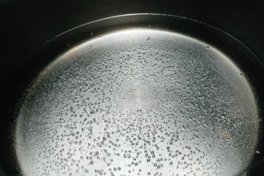 Köpüklü kaynar su yakın plan, evcil bir mutfaktaki sıvı ısıtmanın detaylı görüntüsü. Ev aletleri, içecek takımı ve yiyecek ve içecek teması..