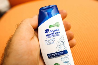 Paris, Fransa - 3 Haziran 2023: Bir insan eli klasik bir kafa ve omuz şampuanı şişesini tutuyor.