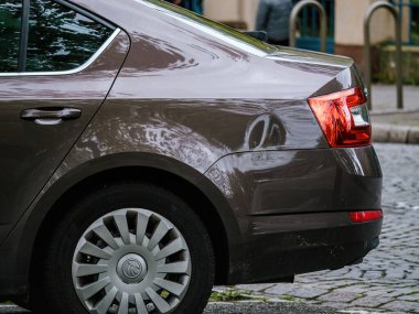 Strasbourg, Fransa - 12 Nisan 2023: Maroon topaz Skoda Octavia yoğun bir caddeye park etmiş, çevresindekileri parlak yüzeyde yansıtarak, ulaşımı ön plana çıkarıyor..