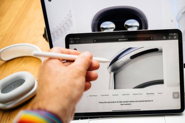 Paris, Fransa - 6 Haziran 2023: Kullanıcı Apple Vision Pro karışık gerçeklik XR kulaklığında uzaysal video ve uzay fotoğrafları çekmek için üst düğmeye işaret ediyor. Fiyatı 3,499 dolar - bilgisayarın geleceği