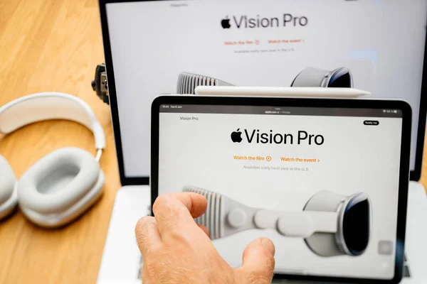 stock image Paris, France - Jun 6, 2023: Tilt-shift lens over creative room table with webpage of Apple on iPad Pro showcasing Apple Vision Pro mixed reality XR headset. Priced 3,499 USD - future of computing