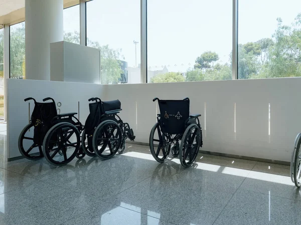 在机场 轮椅靠窗停放在室内 展示医疗设备和交通设施 没有人在场 强调无障碍环境和不同的能力 — 图库照片