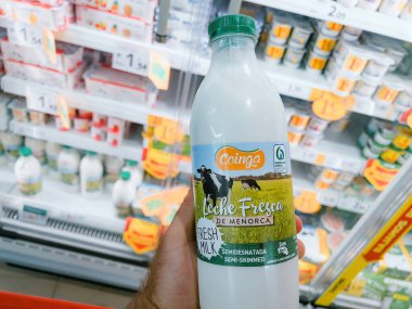 Mallorca, İspanya - 22 Haziran 2023: Pov erkek el ele tutuşması Coinga Leche Fresca de Menorca - süpermarketten taze süt alımı