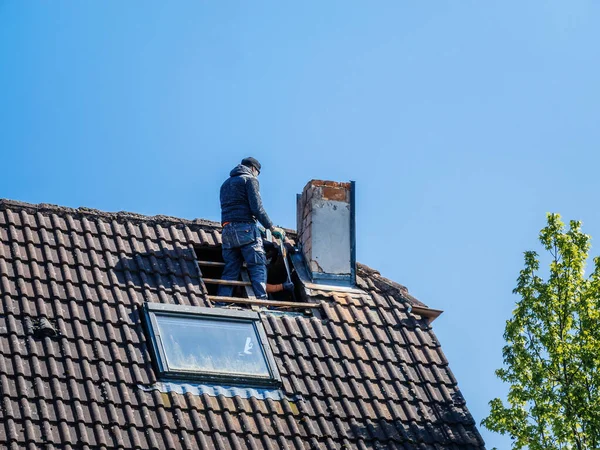 屋根の外側の建物に取り組んで屋根のチームは 明確な空の下で煙突を修復し — ストック写真