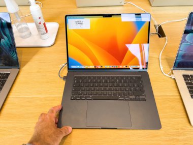 Strasbourg, Fransa - 10 Temmuz 2023: New MacBook Air yeni 15 inçlik uzay gri dizüstü bilgisayarı - özelliklerini keşfetmeye çalışan adam ve 1599 avroluk başlangıç fiyatı
