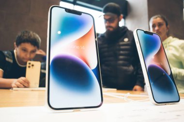 Paris, Fransa - 22 Eylül 2022: Yeni iPhone 'lu kahraman nesne 14 akıllı telefon ve arka plandaki müşteriler cihazı test ederken mutlular - aile kızı ve babası
