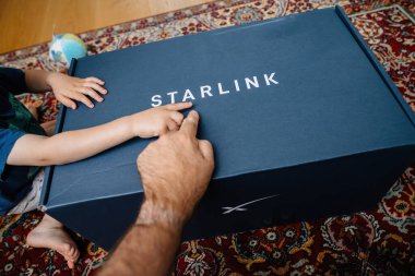 Bremen, Almanya - 14 Ağustos 2023: Baba ve oğul, Elon Musk tarafından işletilen uydu internet takımyıldızını kullanarak yeni SpaceX Starlink çanak çanak çanağına işaret ediyorlar.