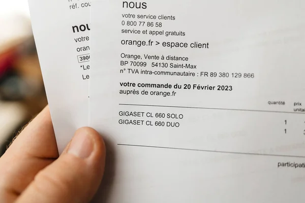 フランス 2023年3月27日 ガガジェットブランドのDct電話2台のための請求書を保持するPov男性の手 — ストック写真