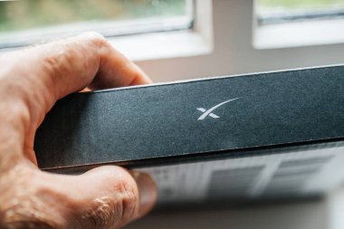 Frankfurt, Almanya - 28 Temmuz 2023: Yeni Ethernet Adaptörünün erkek el ele tutuşması paketi, bir aygıtı kablolu internet bağlantısı için Starlink yönlendiricisine doğrudan bağlamak üzere tasarlandı - SpaceX logotype