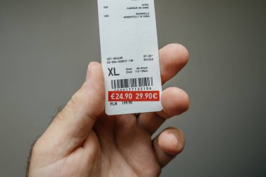 Paris, Fransa - 12 Temmuz 2023: POV - Bir kağıt etiket, maddeyi 29,90 avrodan daha cazip bir 24,90 avroya düşürerek fiyatta belirgin bir indirim gösteriyor. Çin etiketinden yapılmış.