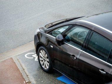 Neufchatel-Hardelot, Fransa - 18 Ağustos 2023: rom bir hava perspektifi, bir Opel minibüsü yağmurlu bir gökyüzünün altında, engelli park alanında park edilmiştir.