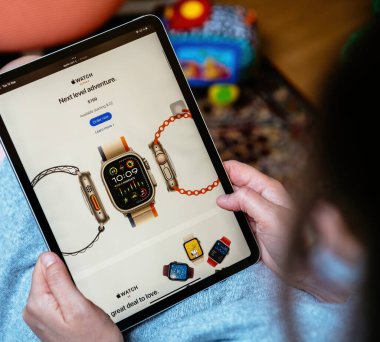 Londra, İngiltere - 13 Eylül 2023: Kadın, iPad Pro tabletini kullanarak, giyilebilir IoT teknolojisinde bir sonraki seviye macera olan Apple Watch Ultra 2 'nin USD799 fiyatından başlayan son özelliklerini araştırıyor.