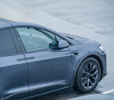 Neufchatel-Hardelot, Fransa - 18 Ağustos 2023: Yukarıdan bakıldığında, bir Tesla Model X elektrikli arabası, sağanak yağış altında kalmış, çok sayıda yağmur damlası sergiliyor