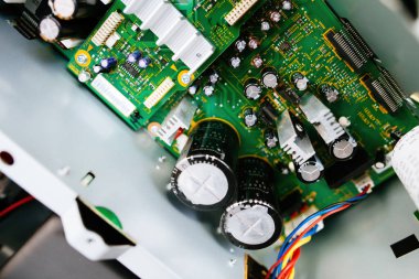 D sınıfı bir amplifikatöre yerleştirilmiş büyük kondansatörlerin görüntüsü, transistörlerin ve işlemcilerin karmaşık yerleşimiyle çevrili..