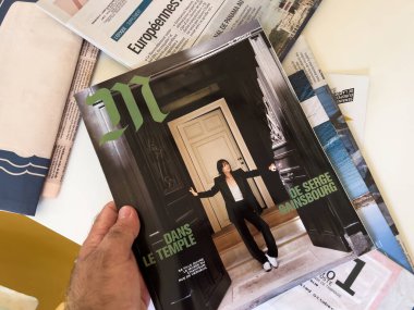 Paris, Fransa - 18 Eylül 2023: El, Le Monde 'un bir eki olan M Magazine' in sayfalarını çevirirken görülüyor. Tapınakta odak başlığı okunuyor