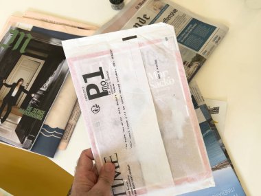 Paris, Fransa - 18 Eylül 2023: Bir adamın yeni alınmış bir Time dergisini, posta kutusundan aldıktan hemen sonra hala koruyucu beyaz kağıt kolunda tutarken görüldü..