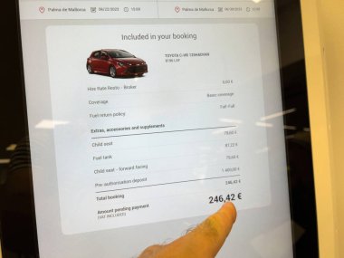 Mallorca, İspanya - 22 Haziran 2023: Bir parmak, Toyota C-HR Hybrid 'in kiralanması için toplam 246.42 Avro' yu gösteren bir otomat ekranına işaret ediyor.