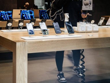Paris, Fransa - 22 Eylül 2023: Bir kadın, Apple Store 'daki iPhone 15 Pro için seçimlerini dikkatlice değerlendiriyor..