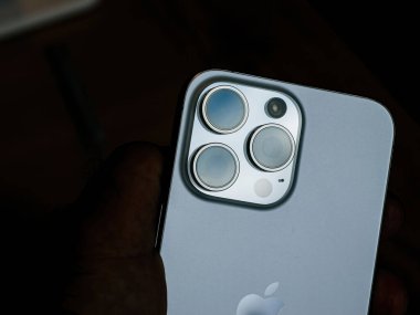 Paris, Fransa - Sep 22, 2023: Erkek eli en son iPhone 15 Pro Max 5x optik zoom, profesyonel düzeyde mobil fotoğrafçılığı özetleyen üçlü lenebilir kamera düzeneği.