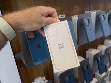 Paris, Fransa - 22 Eylül 2023: Fırlatma gününde kalabalık bir Apple mağazasının içinde, anlayışlı bir müşteri 15 inçlik bir Apple çantasını magsafe ile şeffaf bir şekilde tutuyor, satın alıp almama konusunda kafa yoruyor.