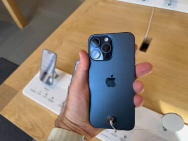 Paris, Fransa - 22 Eylül 2023: Sabırsızlıkla beklenen fırlatma gününde Apple Store 'un içinde, meraklı bir müşteri yeni iPhone 15 Pro.