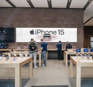 Paris, Fransa - Bölüm 22, 2023: Dahiler olarak bilinen tanınmayan Apple Store personeli, müşterilere yoğun perakende ortamında en son iPhone 15 Pro seçenekleri üzerinden rehberlik ediyor..