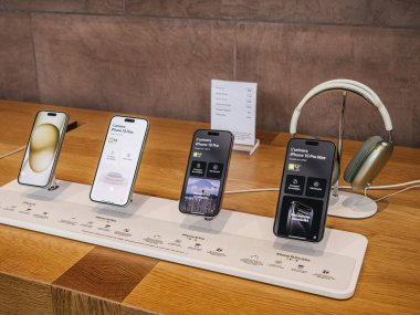 Paris, France - Sep 22, 2023: On the global launch day, a customer-centric presentation displays the latest iPhone 15 series models 15, 15 Plus, 15 Pro, and Pro Max beside the AirPods Max headphones. clipart