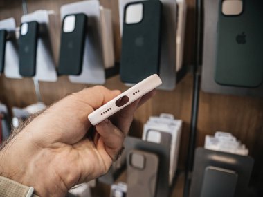 Paris, Fransa - 22 Eylül 2023: Bir Apple Store 'da, bir erkek, iPhone 15 Pro için özel olarak tasarlanmış en son kutuyu, çeşitli çantaların sergilendiği tezgahın yakınındaki silikon bir kutuyu inceliyor.