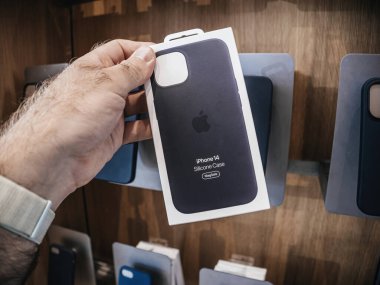 Paris, Fransa - 22 Eylül 2023: Bir erkek, Apple Store sınırları içinde iPhone 14 ile kullanılmak üzere MagSafe kapasiteli silikon bir çanta sergiliyor.