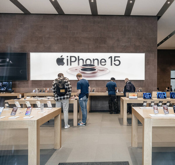 Paris, France - Sep 22, 2023: Unrecognizable Apple Store staff, known as Geniuses, guide customers through the options for the latest iPhone 15 Pro in the bustling retail environment.