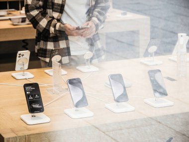 Paris, Fransa - 22 Eylül 2023: Apple mağazasının içinde meraklı bir müşterinin sokak görüntüsü, uluslararası tanıtım gününde yeni iPhone 15 Pro 'yu test ediyor