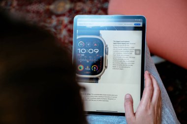 Londra, İngiltere - 13 Eylül 2023: Apple Watch Ultra 2 'nin yeni S9 SiP işlemcisi hakkında iPad Pro' da okuyan kadın, her zaman 3000 bit ile retina ekranı ve Apple.com 'da ayrıntılı olarak belirtildiği gibi yeni gece modu özellikleri