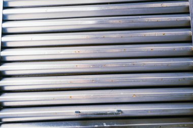 Yakın çekim, paslanmaz çelik bir mutfak kaputundan alınan yağlı bir filtreyi yakalıyor.