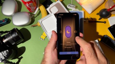 Londra, İngiltere - 25 Eylül 2023: Yaratıcı bir şekilde tasarlanmış bir odada yeni titanyum iPhone 15 Pro üzerinde Action düğmesi ile etkileşime giren bir erkeğin yakın çekimi