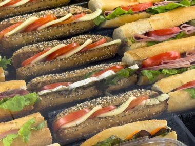 Bir dizi lezzetli sandviçler mozzarella, domates, jambon ve buzdağı salatası çeşitli ekmek türleri üzerinde sunulmaktadır..